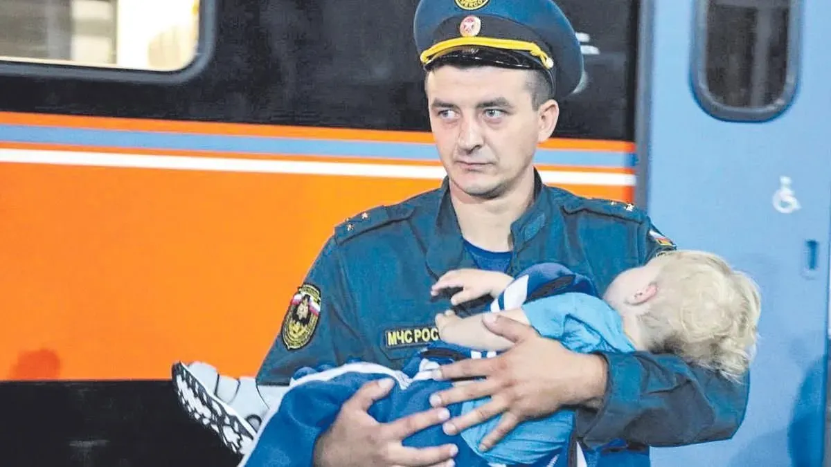 Personal del Ministerio para las Situaciones de Emergencia de Rusia traslada a un niño recién evacuado de Kursk. Personal del Ministerio para las Situaciones de Emergencia de Rusia traslada a un niño recién evacuado de Kursk.