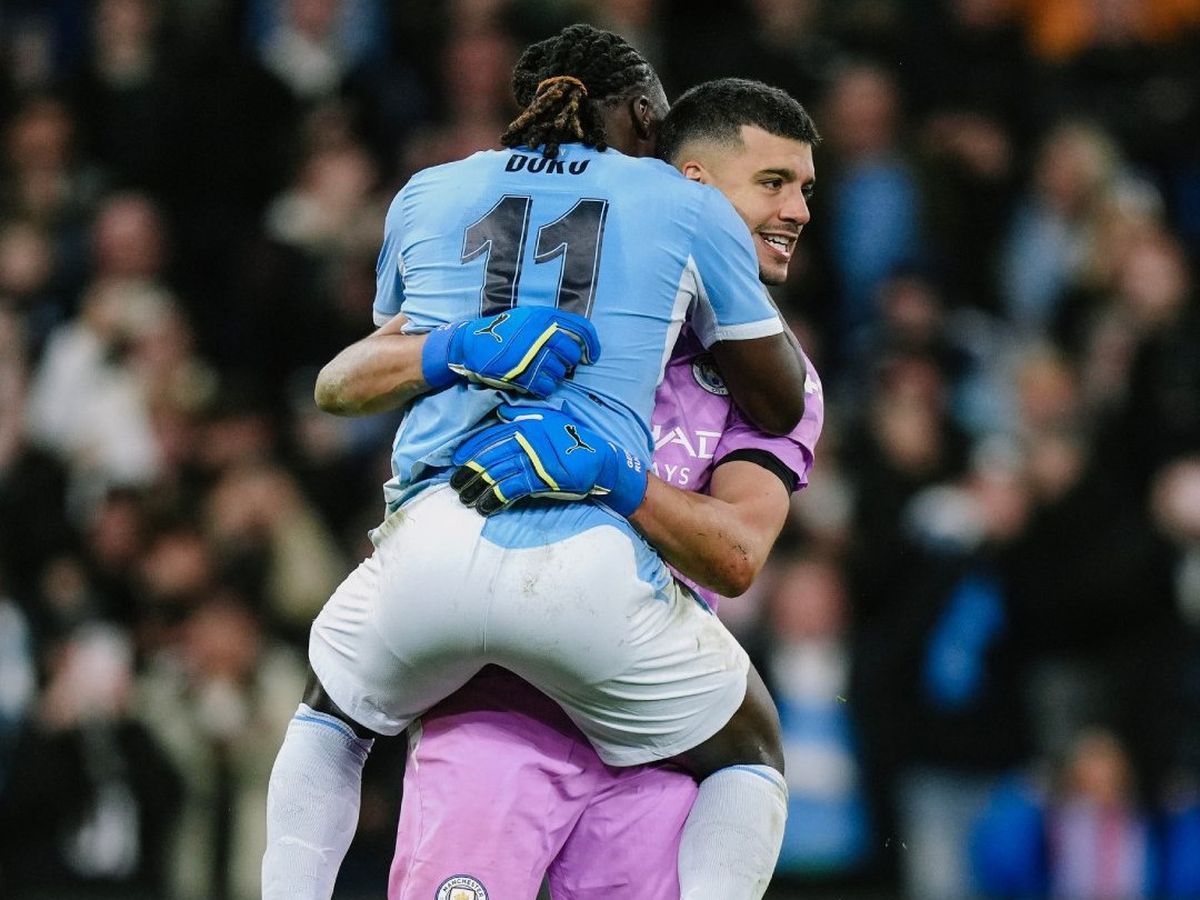 Gerónimo Rulli festeja con su compañero de Manchester City, el belga Jeremy Doku