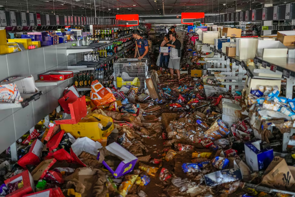 La gente recoge productos en un supermercado afectado por las inundaciones en Valencia, España. La gente recoge productos en un supermercado afectado por las inundaciones en Valencia, España.