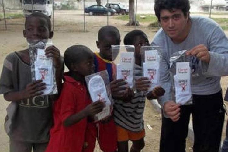 Benítez junto a los niños angoleños mostrando las medias.