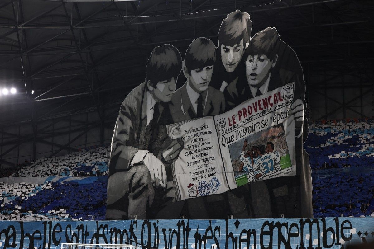 Imagen de los Beatles leyendo un ejemplar de un periódico regional del sur de Francia en las gradas antes del partido de fútbol de la séptima jornada de la fase de grupos de la UEFA Champions League entre el Olympique de Marsella (OM) y el Liverpool FC en el Stade Vélodrome de Marsella. Foto AFP.