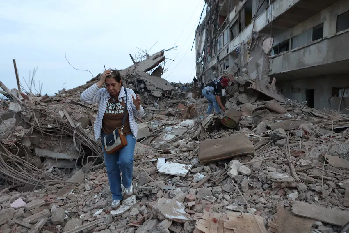 Una mujer camina entre los escombros de un edificio derrumbado por terremoto en Catia La Mar, Venezuela. | PEDRO MATTEY (AP/LAPRESSE) Una mujer camina entre los escombros de un edificio derrumbado por terremoto en Catia La Mar, Venezuela. | PEDRO MATTEY (AP/LAPRESSE)