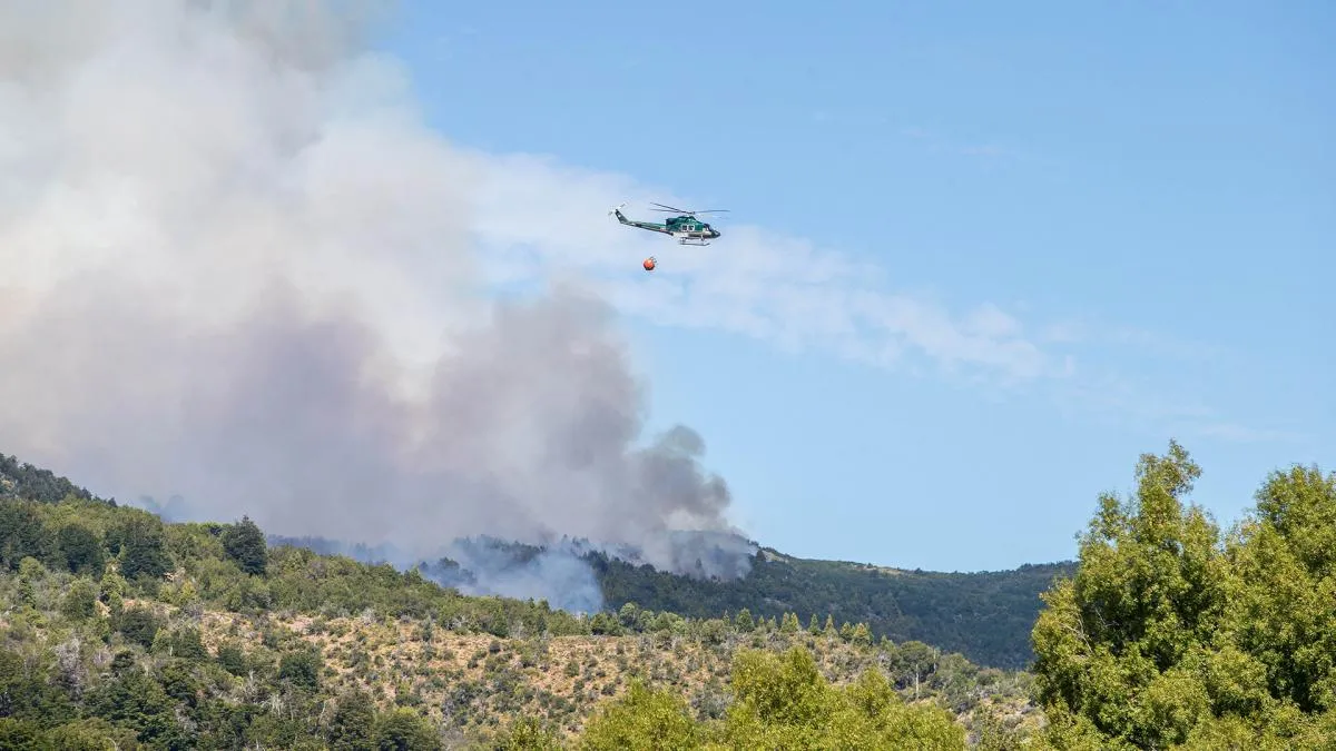 Un helic&oacute;ptero vuela sobre el incendio en Los Alerces.