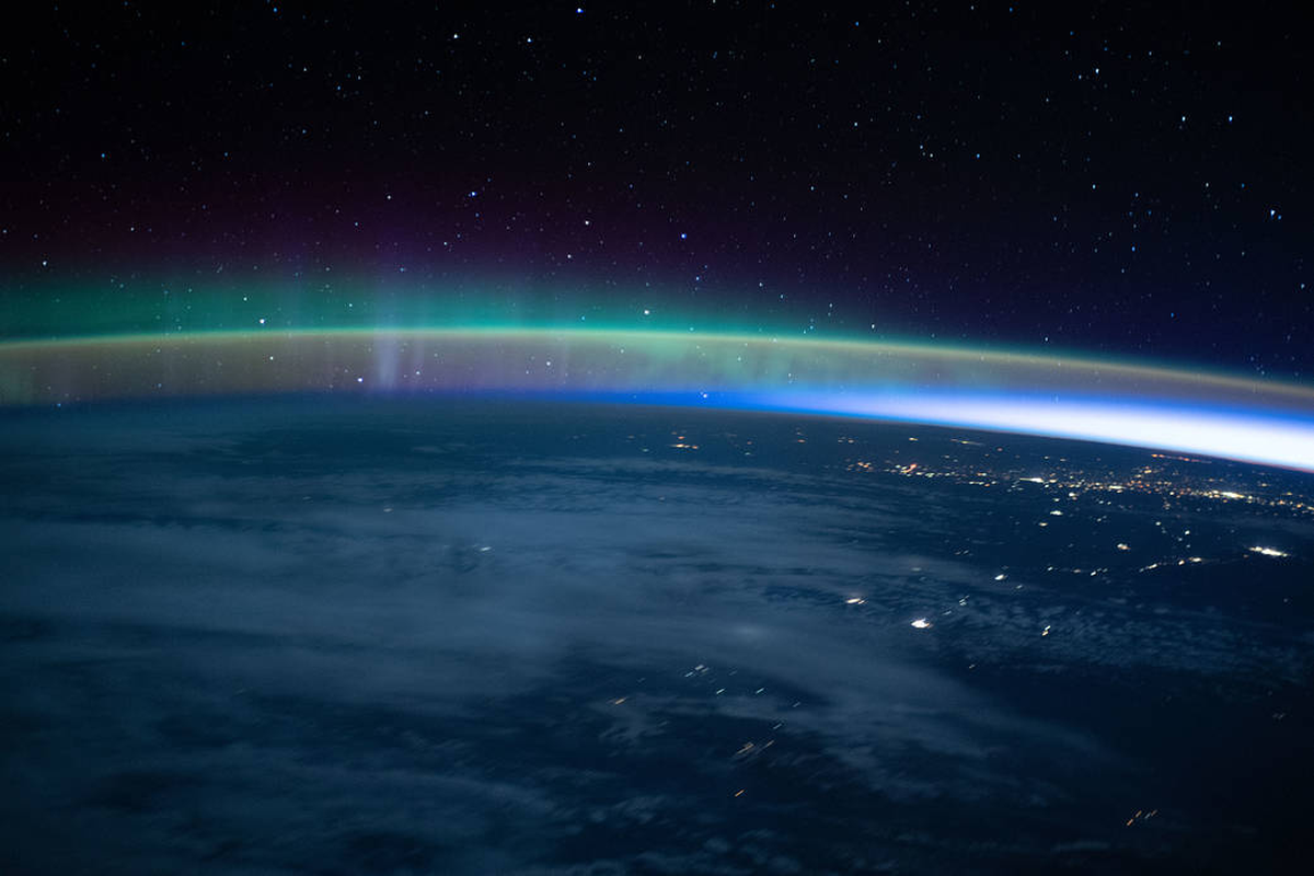 Una aurora se cruzó tenuemente con el resplandor del aire de la Tierra cuando la Estación Espacial Internacional voló hacia un amanecer orbital a 264 millas sobre el Océano Pacífico. 
