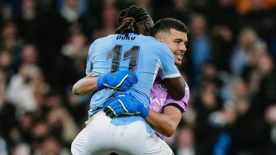 Gerónimo Rulli festeja con su compañero de Manchester City, el belga Jeremy Doku
