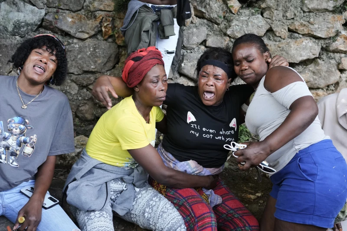 Mujeres lloran en el lugar donde sus familiares fueron asesinados en un ataque de pandillas en el barrio de Kenscoff, en Puerto Pr&iacute;ncipe, Hait&iacute;, el lunes 24 de agosto de 2026. (Foto AP/Odelyn Joseph)
