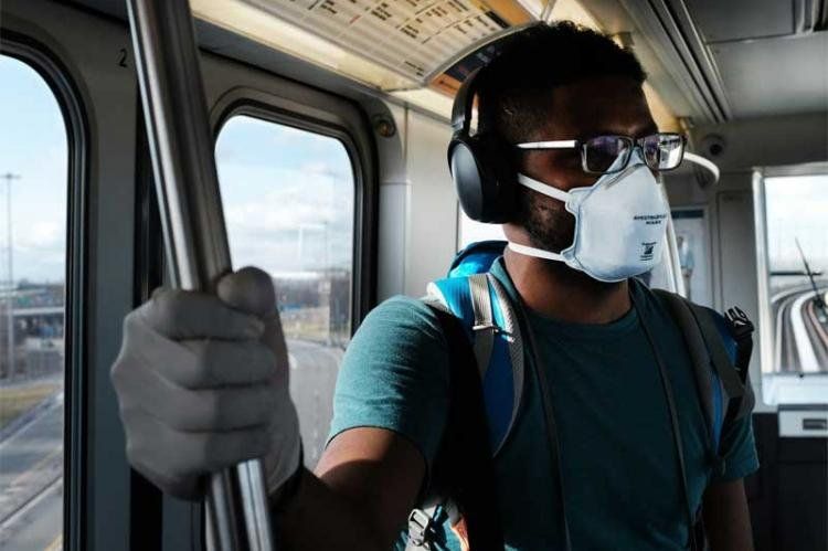 No es una imagen de China: Un hombre usa una máscara médica en el AirTrain en el camino al Aeropuerto Internacional John F. Kennedy en Nueva York.