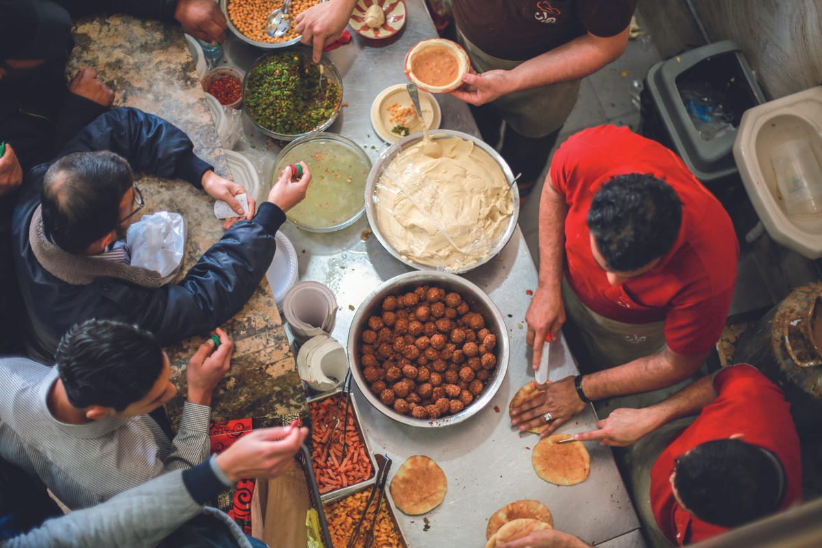 El hummus deriva del árabe y significa "garbanzos". Se origina en Medio Oriente, aunque los historiadores no coinciden de cuál es el país exacto del que surge. El hummus deriva del árabe y significa "garbanzos". Se origina en Medio Oriente, aunque los historiadores no coinciden de cuál es el país exacto del que surge.