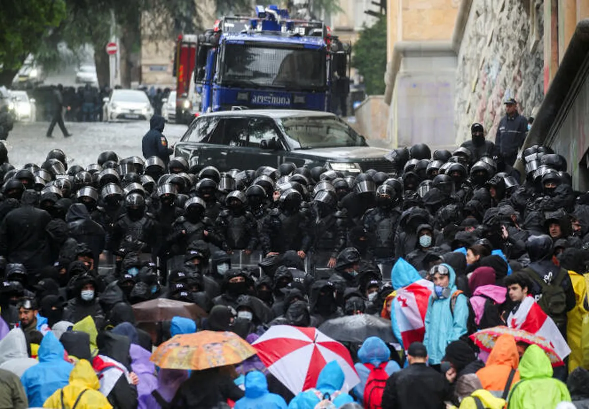 Parlamentarios de Georgia entran al Parlamento detrás de un muro de policías, durante la manifestación contra el proyecto de ley sobre Parlamentarios de Georgia entran al Parlamento detrás de un muro de policías, durante la manifestación contra el proyecto de ley sobre