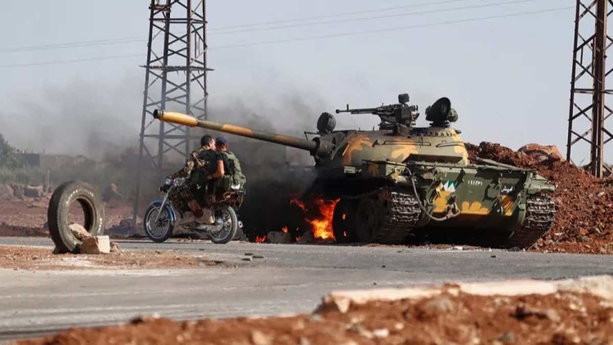 Soldados del Gobierno sirio junto a un tanque en llamas en las afueras de la ciudad de Sweida, en el sur de Siria, el lunes 14 de julio de 2025 | GENTILEZA EURONEWS Soldados del Gobierno sirio junto a un tanque en llamas en las afueras de la ciudad de Sweida, en el sur de Siria, el lunes 14 de julio de 2025 | GENTILEZA EURONEWS