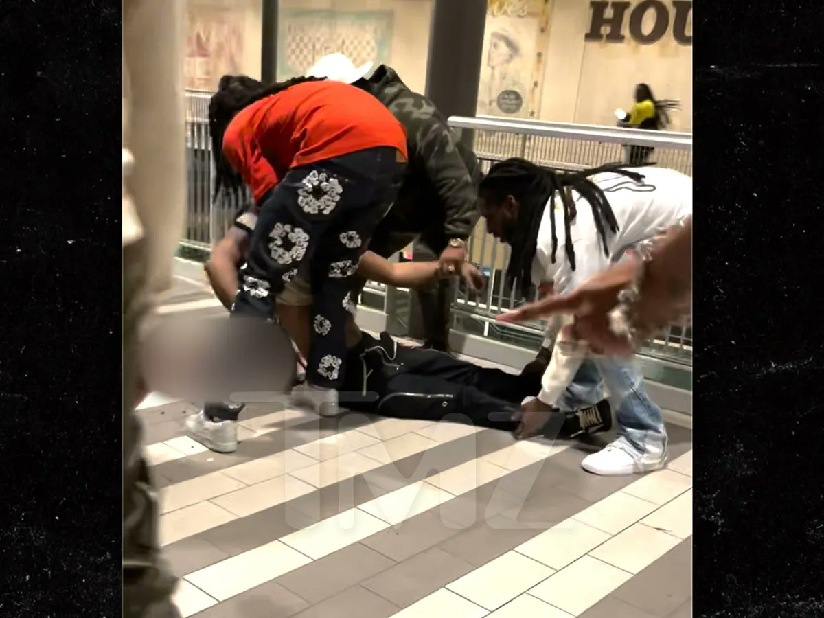 El tío (de remera naranja) conocido como Quavo, cerca del cadáver de Takeoff cuya cabeza está sobre su propio charco de sangre.