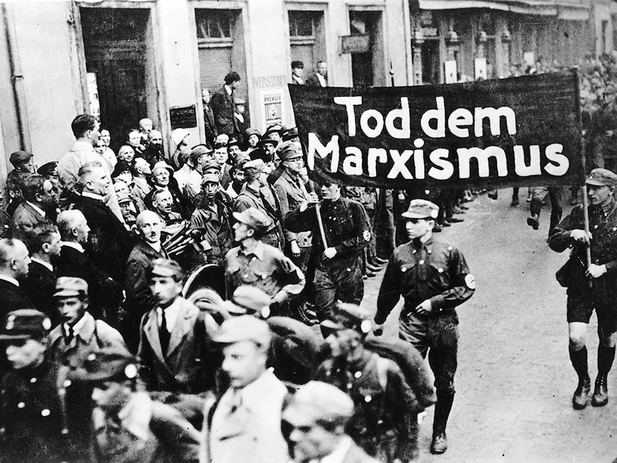 Contrario a lo que piensa Javier Milei (y sus fanáticos, dicho sea de paso), el nazismo no era de izquierda. Odiaban el socialismo, el comunismo y hasta el sindicalismo. En esta foto, por ejemplo, se ve a dos soldados nazis sosteniendo una pancarta que dice Contrario a lo que piensa Javier Milei (y sus fanáticos, dicho sea de paso), el nazismo no era de izquierda. Odiaban el socialismo, el comunismo y hasta el sindicalismo. En esta foto, por ejemplo, se ve a dos soldados nazis sosteniendo una pancarta que dice
