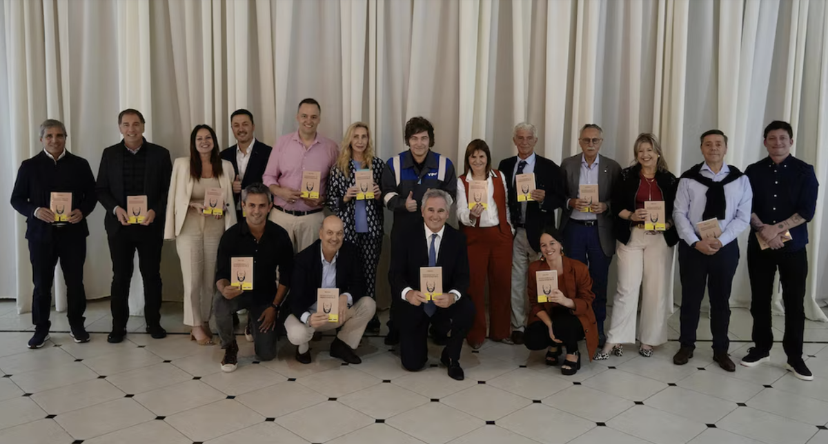 Milei posando con su gabinete, a quienes les regaló un curioso libro.