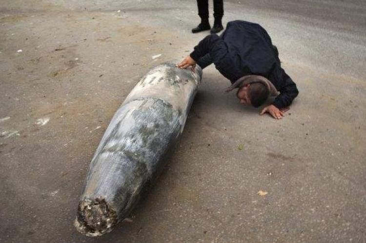 Militante de Hamas inspecciona una bomba israelí que no explotó.