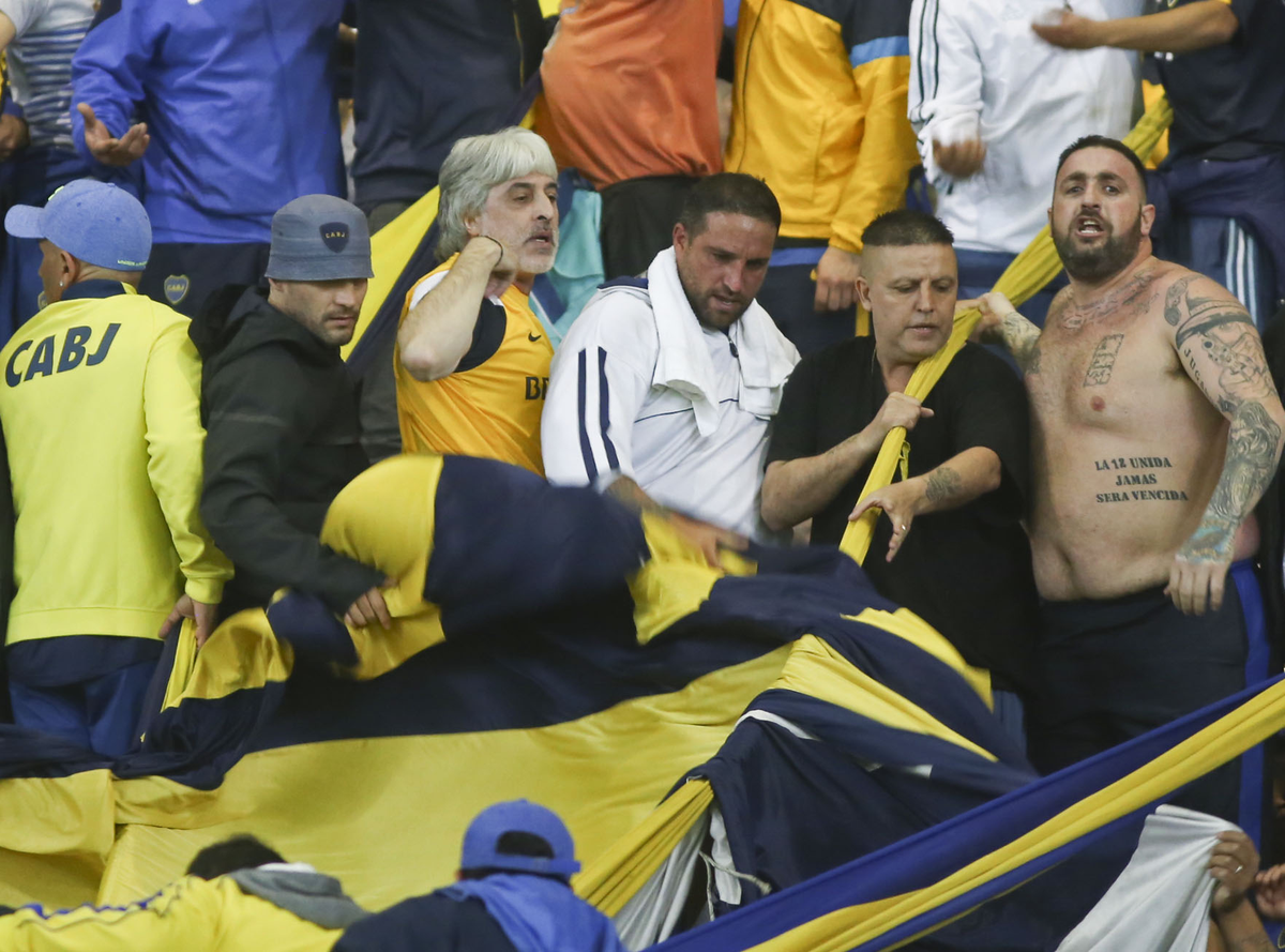 Rafael di Zeo volverá a las tribunas en un partido de Boca. Mauro Martín -de negro y con piluso gris en la foto- no logró pasar los controles y se tuvo que regresar a nuestro país. (Foto: Noticias Argentinas).