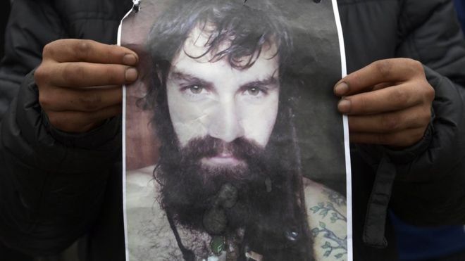 Afiche con la foto de Santiago Maldonado mientras se identifica el cadáver encontrado en el río Chubut
