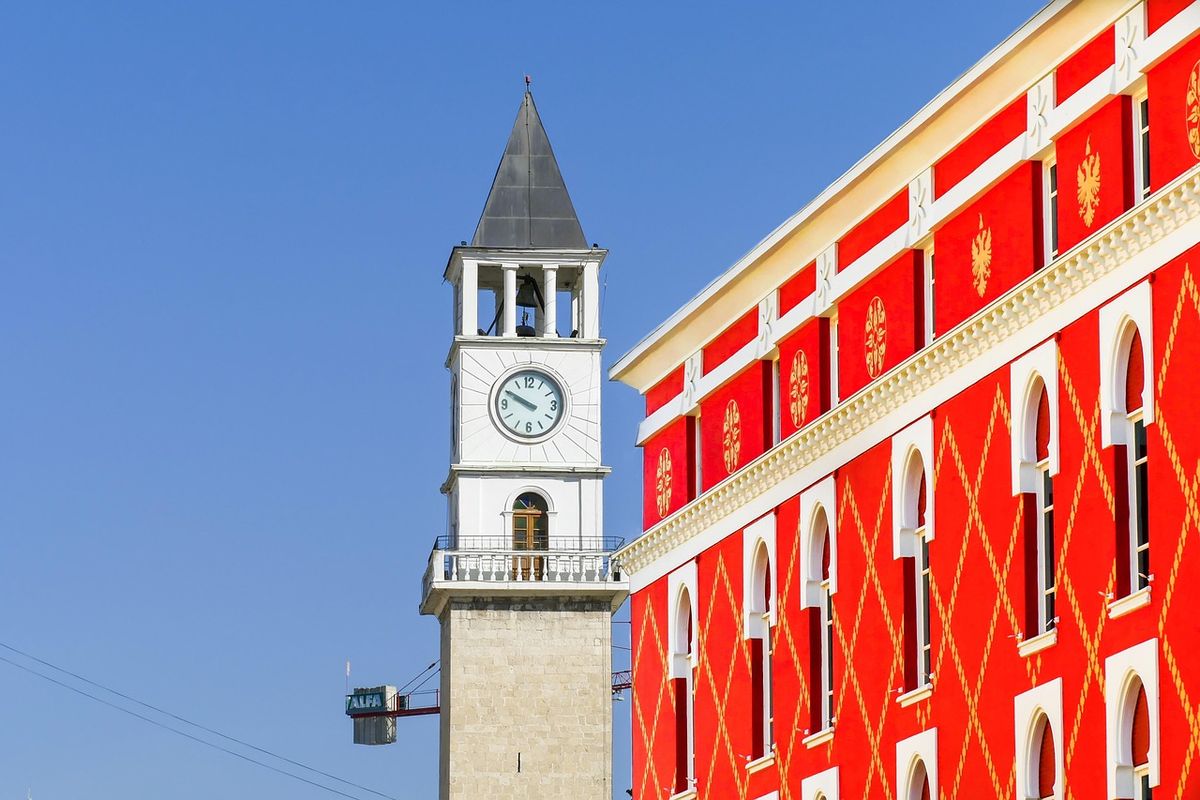 Un reloj urbano marca el pulso de Tirana, entre edificios heredados del comunismo y nuevas capas de arquitectura contemporánea. Un reloj urbano marca el pulso de Tirana, entre edificios heredados del comunismo y nuevas capas de arquitectura contemporánea.