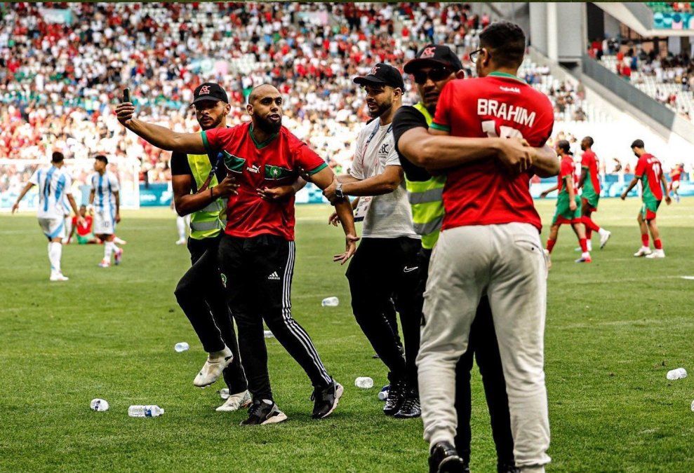 Fuerzas de seguridad conteniendo a hinchas marroquíes que ingresaron al campo de juego tras el empate de Argentina Fuerzas de seguridad conteniendo a hinchas marroquíes que ingresaron al campo de juego tras el empate de Argentina