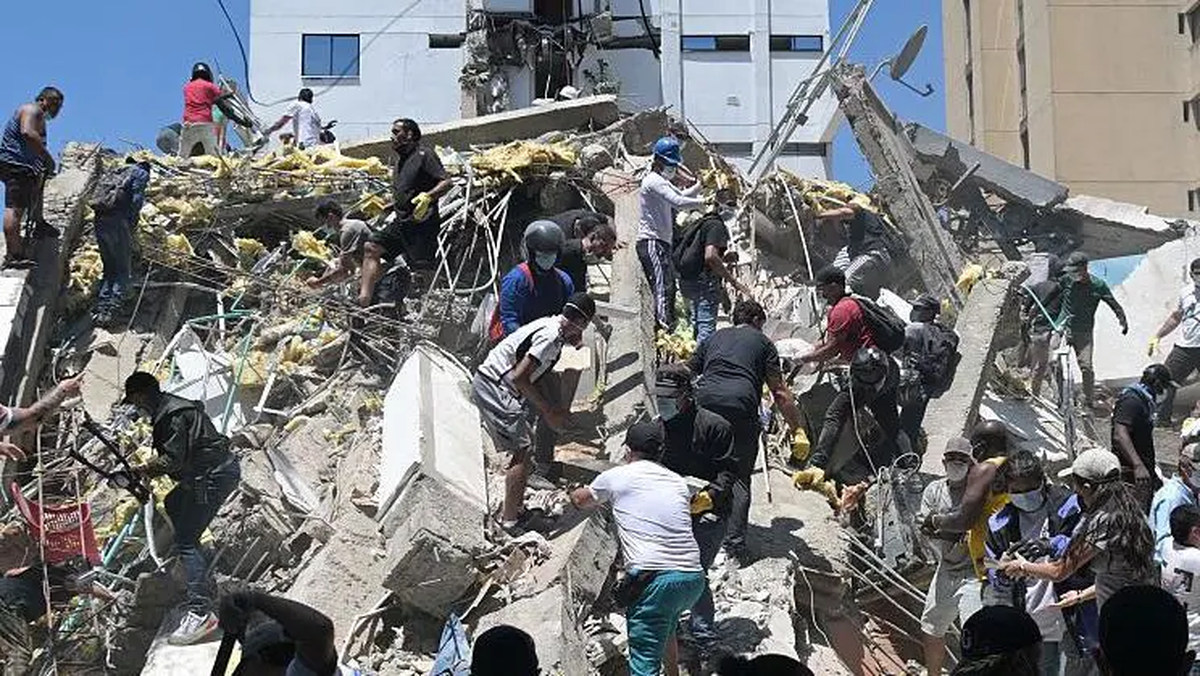 Personas buscan sobrevivientes entre los escombros de un edificio derrumbado tras un terremoto en Cali. Personas buscan sobrevivientes entre los escombros de un edificio derrumbado tras un terremoto en Cali.