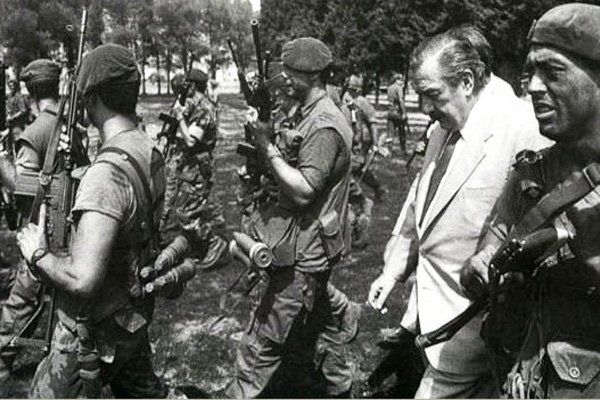 Raúl Alfonsín, quien inicialmente se empeñó en adjudicar el intento de copamiento del BIM3 a los carapintadas, recorre el campo de batalla luego de la derrota del Movimiento Todos por la Patria.