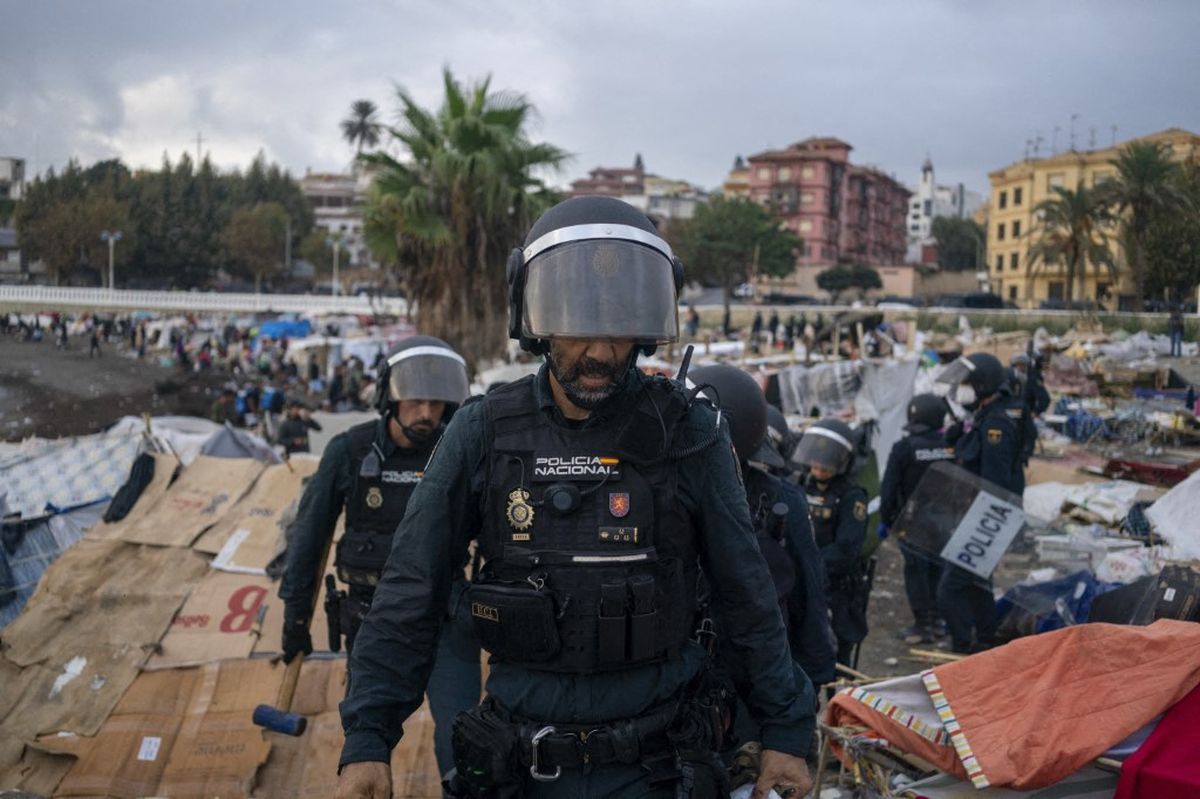 Agentes antidisturbios despejan parte del campamento de la playa de Benítez, en Ceuta, el 27 de septiembre, para establecer un perímetro de seguridad alrededor de la planta desalinizadora. Agentes antidisturbios despejan parte del campamento de la playa de Benítez, en Ceuta, el 27 de septiembre, para establecer un perímetro de seguridad alrededor de la planta desalinizadora.