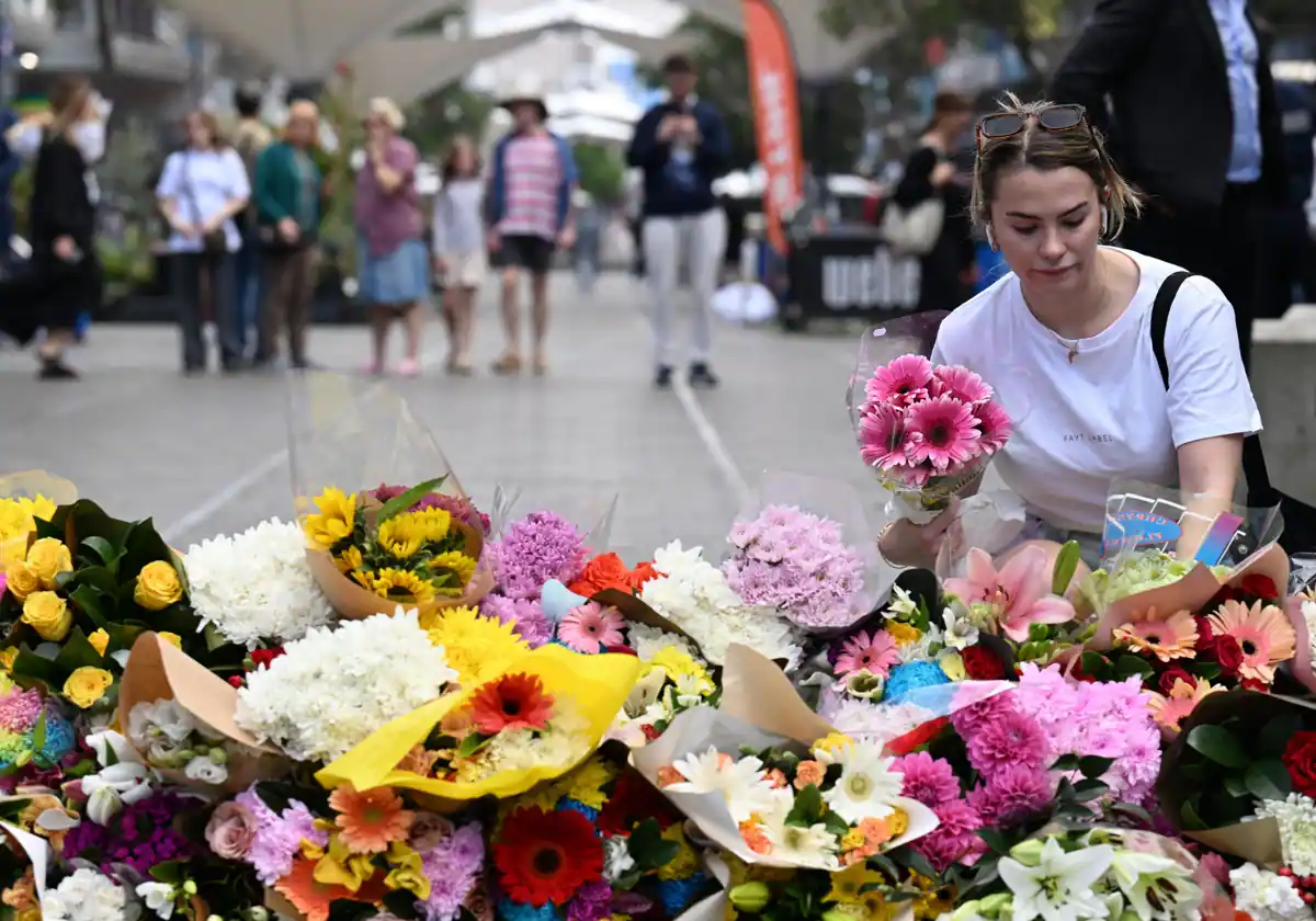 Una mujer rinde homenaje y deposita flores en el lugar del apuñalamiento EFE