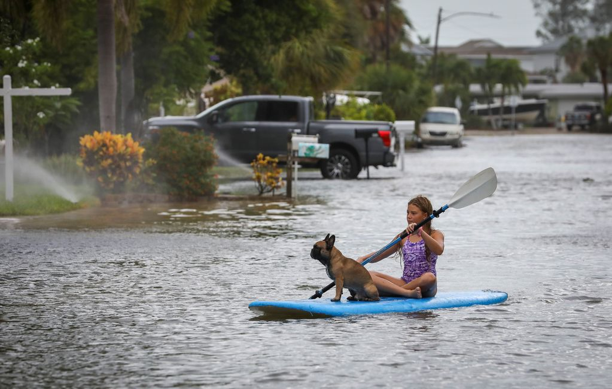 Una niña con su perro navegando por las calles de Florida (Chris Urso/Tampa Bay Times via AP) Una niña con su perro navegando por las calles de Florida (Chris Urso/Tampa Bay Times via AP)