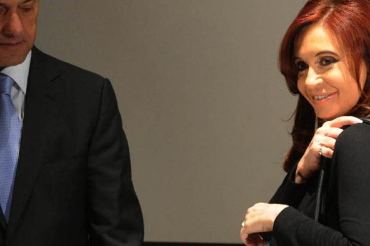Cristina exhibe una de sus carteras durante un acto público con Daniel Scioli