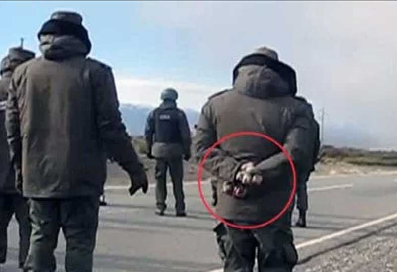 La imagen que muestra a un gendarme con piedras en sus manos. Ahora se conocieron más audios comprometedores.