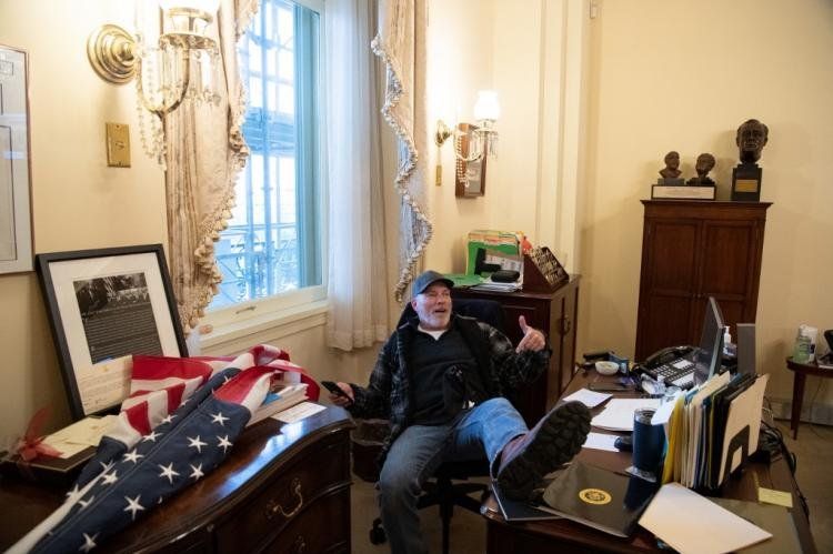 Richard Barnett, un partidario del presidente de Estados Unidos, Donald Trump, se sienta dentro de la oficina de la presidenta de la Cámara de Representantes de Estados Unidos, Nancy Pelosi, mientras protesta dentro del Capitolio de Estados Unidos en Wash