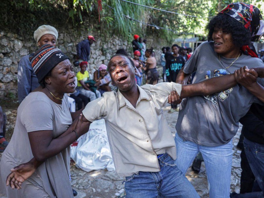 Un joven llora delante de uno de los óbitos de una de las personas que fue acribillada a balazos, en las afueras de Puerto Príncipe, en Kenscoff, Haití, el 24 de agosto de 2026.