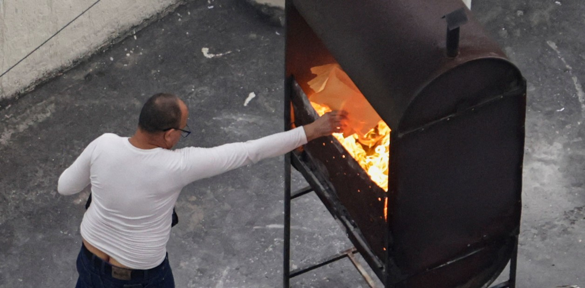 Empleado de la embajada de Cuba quema papeles en la terraza del edificio (Foto Reuters) Empleado de la embajada de Cuba quema papeles en la terraza del edificio (Foto Reuters)