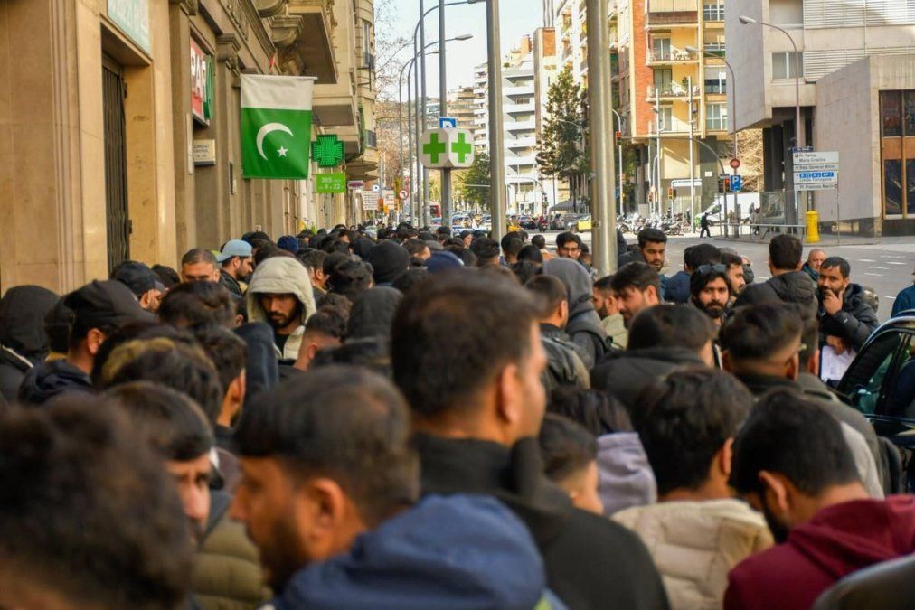 Afuera del Consulado de Pakistán en Barcelona, personas aguardan para tramitar el certificado de antecedentes penales, requisito clave de la regularización.