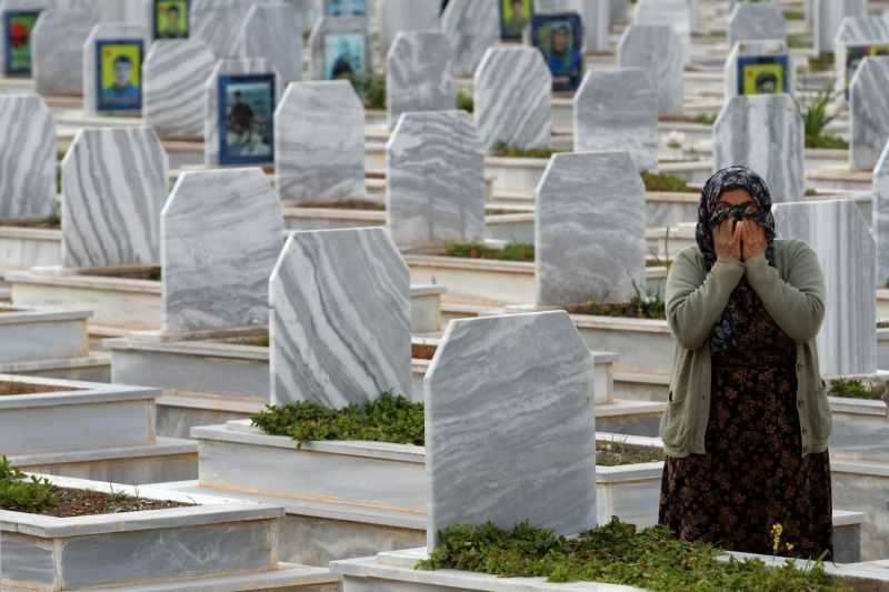 Familiares de combatientes caídos de las Fuerzas Democráticas Sirias visitan sus tumas en Kobane, en marzo. /Foto: GIUSEPPE CACACE/AFP/GETTY IMAGES