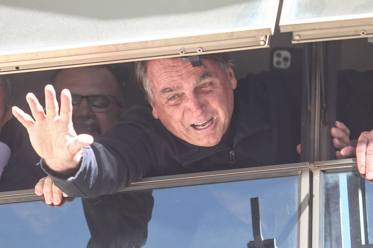 Bolsonaro saluda a simpatizantes a través de la ventana de la sede del PL, en Brasilia