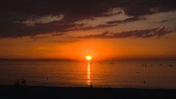 Turistas descansan sobre la arena en Barcelona, donde los altos precios del alojamiento empujan a algunos visitantes a pasar la noche directamente en la playa.