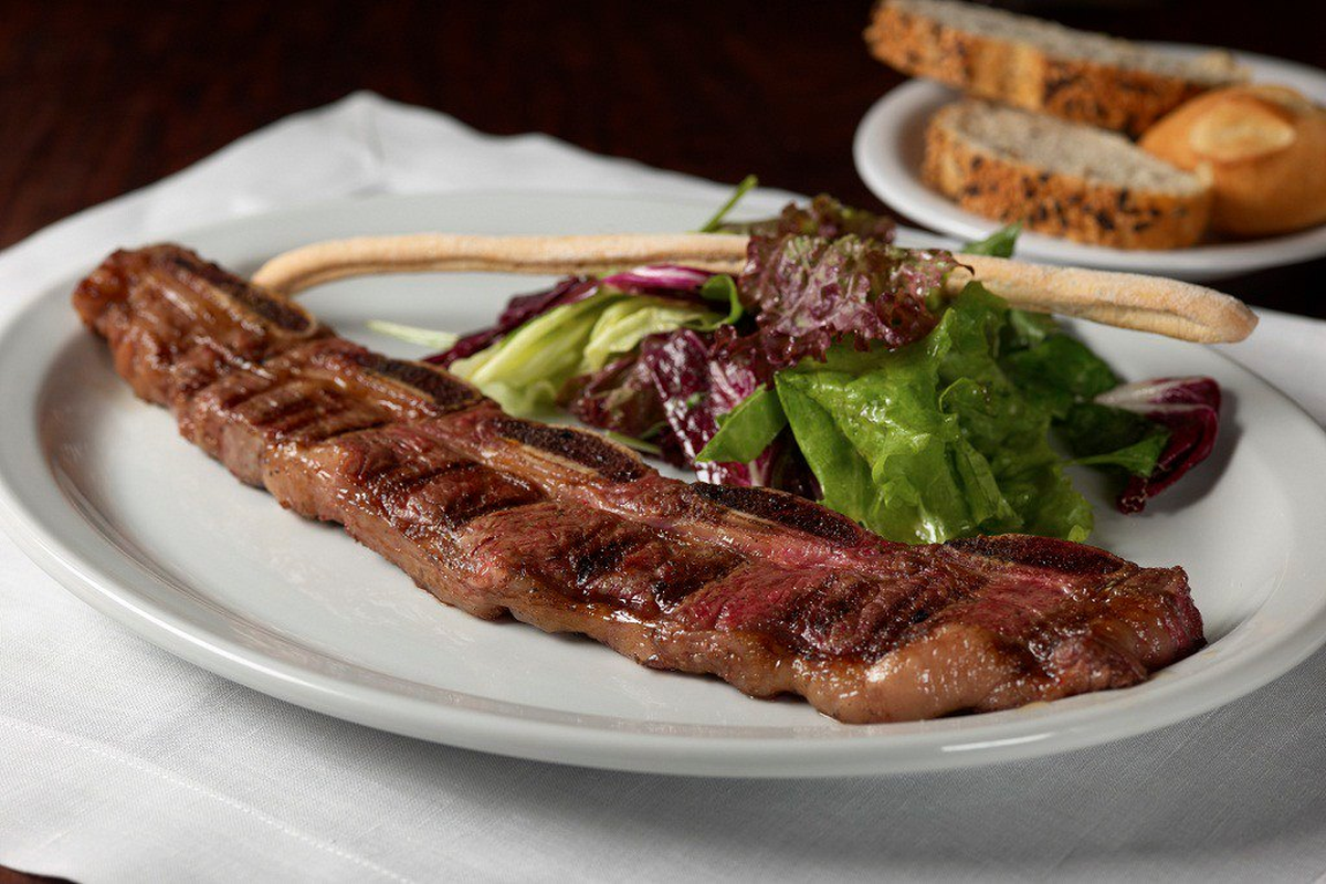 Costillitas de carne acompañadas de ensalada de rúcula, uno de los platos que ofrece la Cabaña Las Lilas.