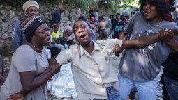 Un joven llora delante de uno de los óbitos de una de las personas que fue acribillada a balazos, en las afueras de Puerto Príncipe, en Kenscoff, Haití, el 24 de agosto de 2026.