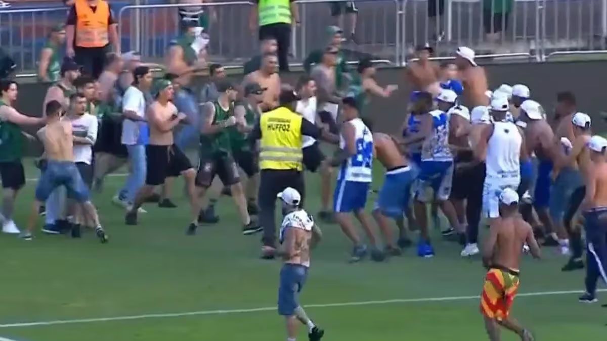 Imágenes del enfrentamiento cuerpo a cuerpo de los hinchas del Cruzeiro y el Coritiba en el campo de juego del estadio Vila Capanema.