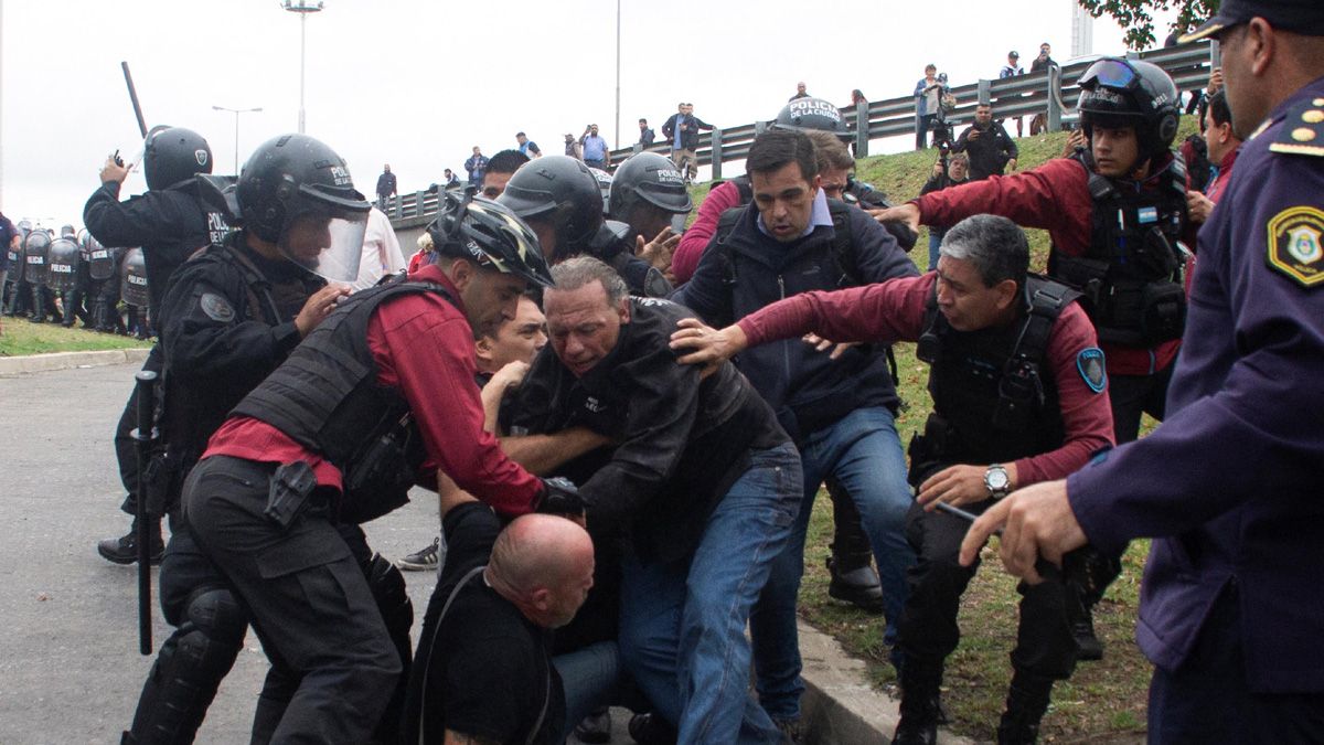 Sergio Berni siendo evacuado por la Policía de la Ciudad, tras la violenta agresión de colectiveros (Foto: Reuters/NA).