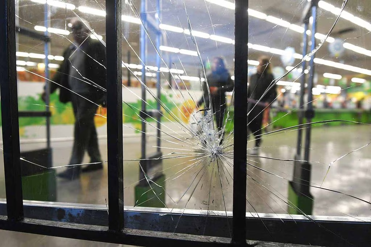 Vidrios rotos en la puerta de ingreso al local del supermercado Vea, en Guaymall&eacute;n (Mendoza), donde un grupo de personas ingresaron e intentaron robar mercader&iacute;a. Foto del diario 'Los Andes'.