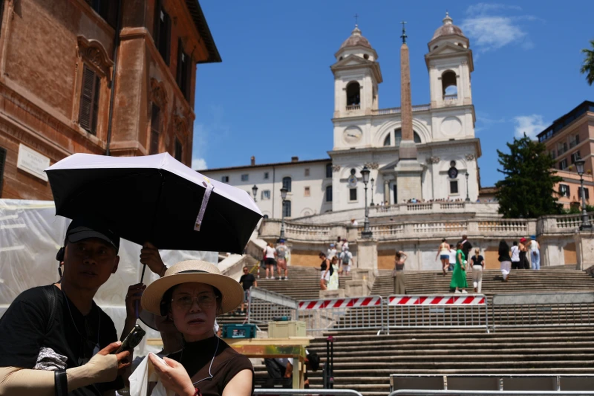 Los turistas usan sombrillas para protegerse del sol mientras visitan la histórica Plaza de España en Roma, el martes 23 de junio de 2026. | Foto AP/Alessandra Tarantino Los turistas usan sombrillas para protegerse del sol mientras visitan la histórica Plaza de España en Roma, el martes 23 de junio de 2026. | Foto AP/Alessandra Tarantino 