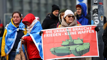 Alemania: Un participante en la manifestación sostiene un cartel que dice Negociar en lugar de escalar. Alemania: Un participante en la manifestación sostiene un cartel que dice Negociar en lugar de escalar.